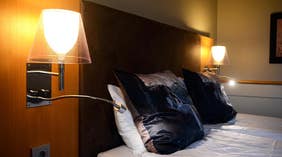 Sänglampa och kudde detalj på Clarion Collection Hotel Kompaniet Nyköping