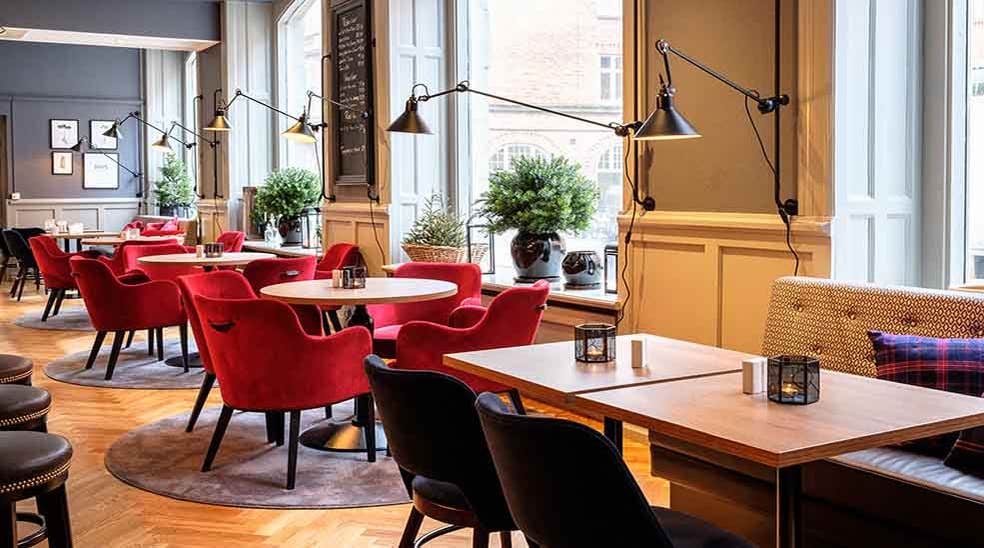 Sittplatser i restaurangen med fåtöljer och fina lampor på Clarion Collection Hotel Temperance i Malmo