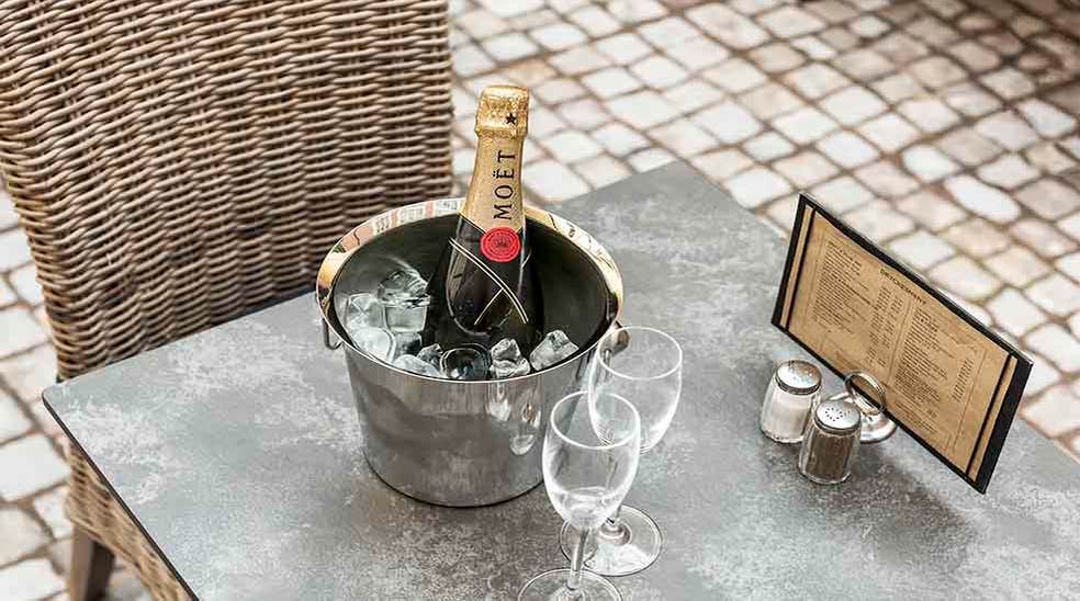  Restaurang med bord och stolar med champagne och meny på Clarion Collection Hotel Victoria Jönköping