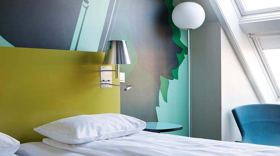 Säng med kudde, lampa och fåtölj i Standard dubbelrum på Comfort Hotel Kristiansand