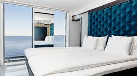 Vox Hotels stora hörnsvit med dubbelsäng i sovrummet och vacker utsikt över Vättern
