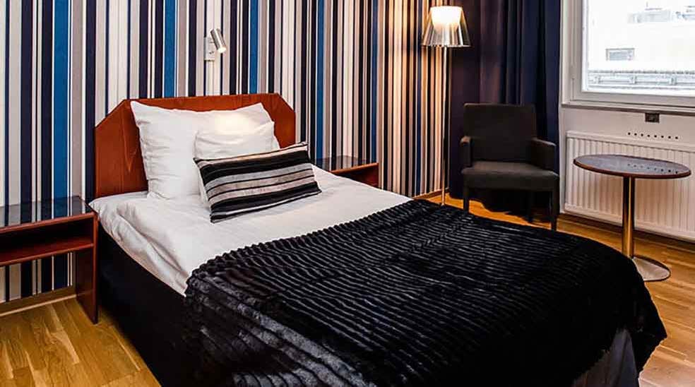 Moderate rum med säng och randig tapet på Quality Hotel Statt i Hudiksvall
